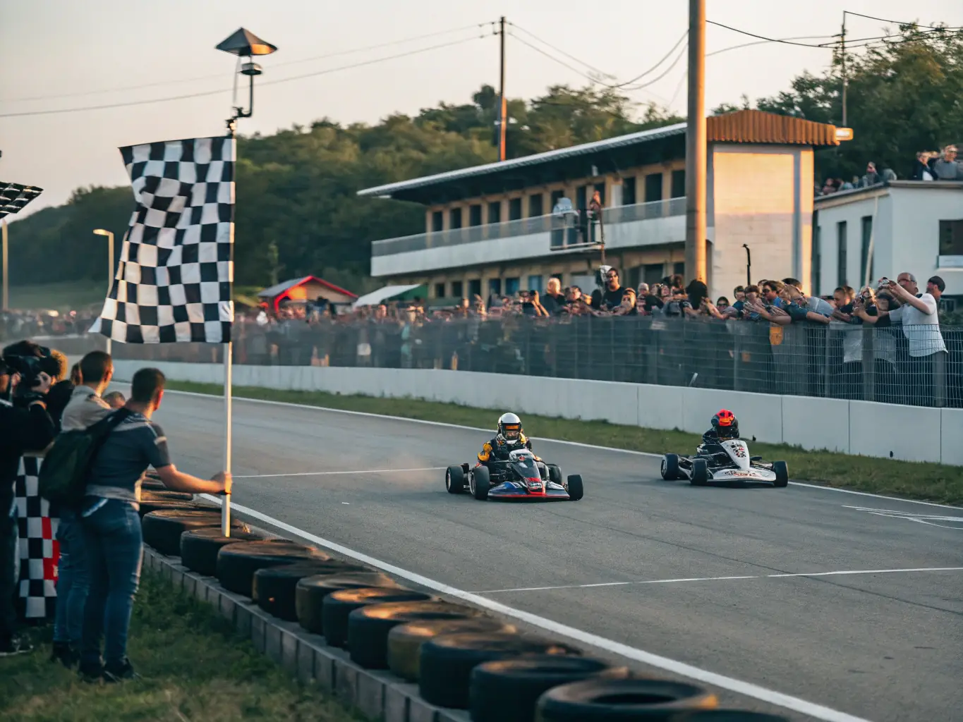A vibrant scene from a karting event organized by LES FRANGINS FALCETTA, showcasing the excitement and community spirit of the competition. The image should capture the thrill of the race and the camaraderie among participants.